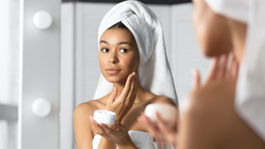 Girl Holding Face Cream Product Hydrating Skin In Bathroom